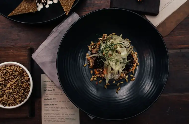 Platillo gourmet servido en un plato negro